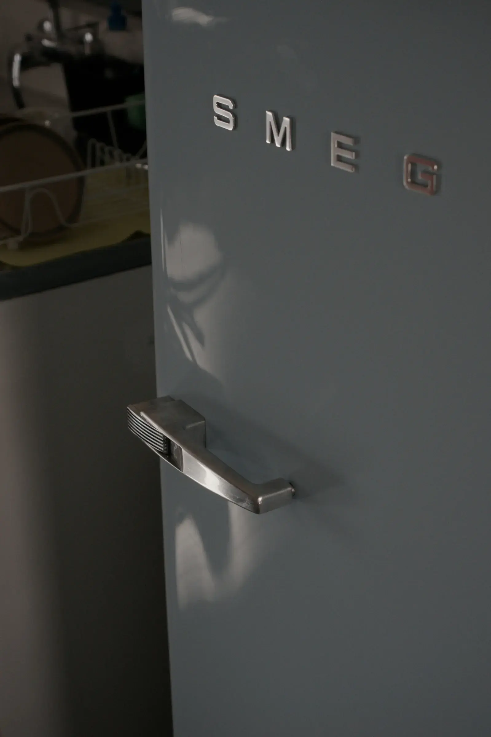 Close detail of a pale blue retro-style fridge freezer door handle