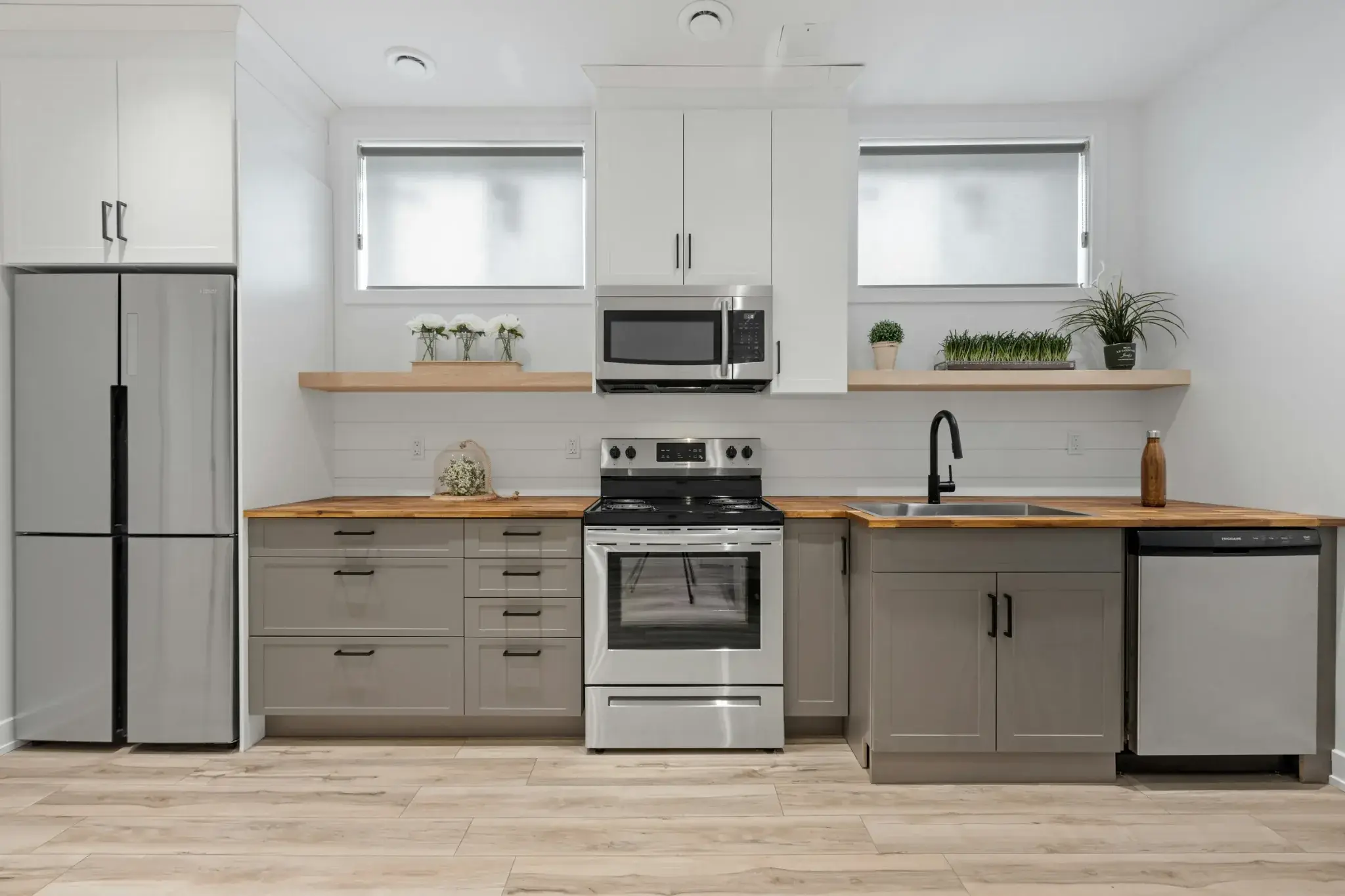 A grey and wood kitchen with appliances along the run of units